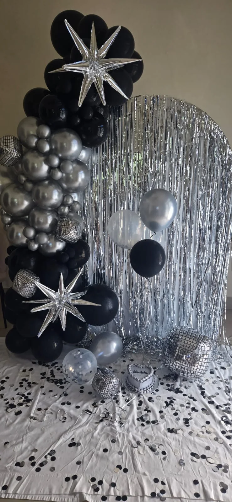 Decoración de globos negros y plateados con estrellas metálicas