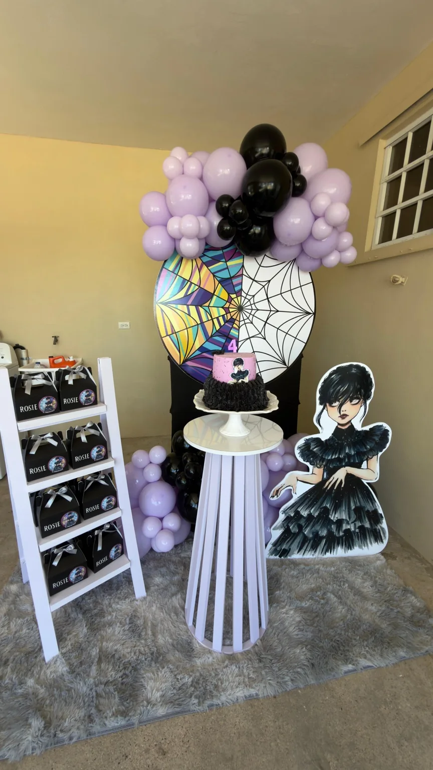 Fiesta temática con globos lila y negros, pastel y mesa decorativa
